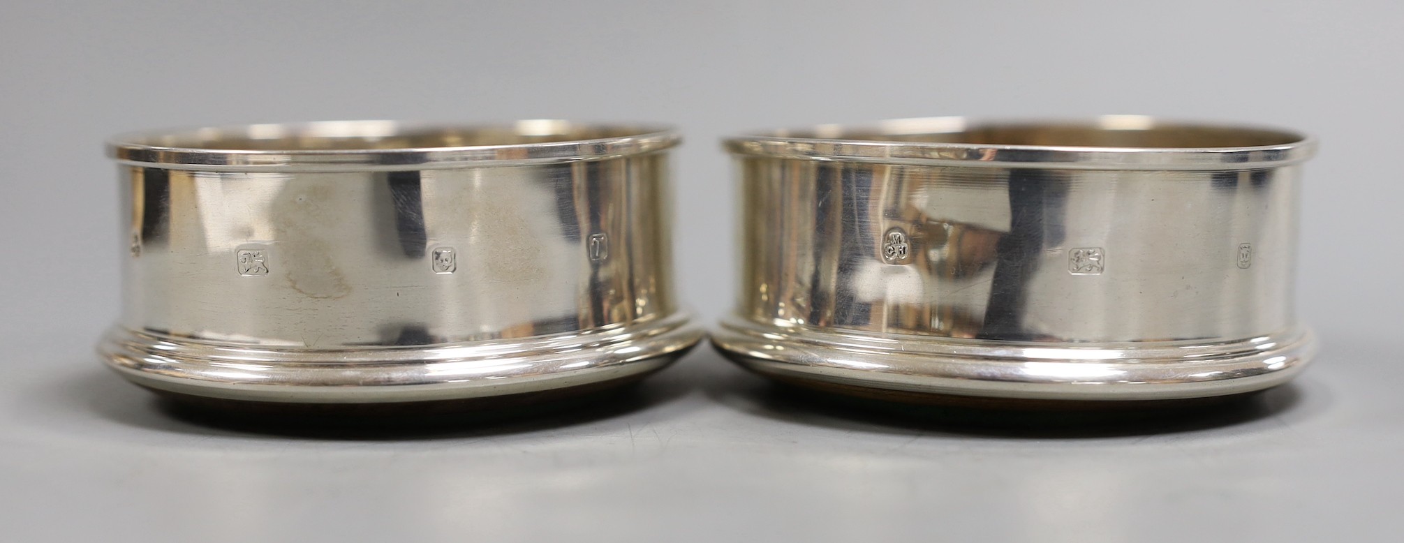 A pair of modern silver mounted wine coasters, M.C. Hersey & Son Ltd, London, 1993, diameter 9cm.